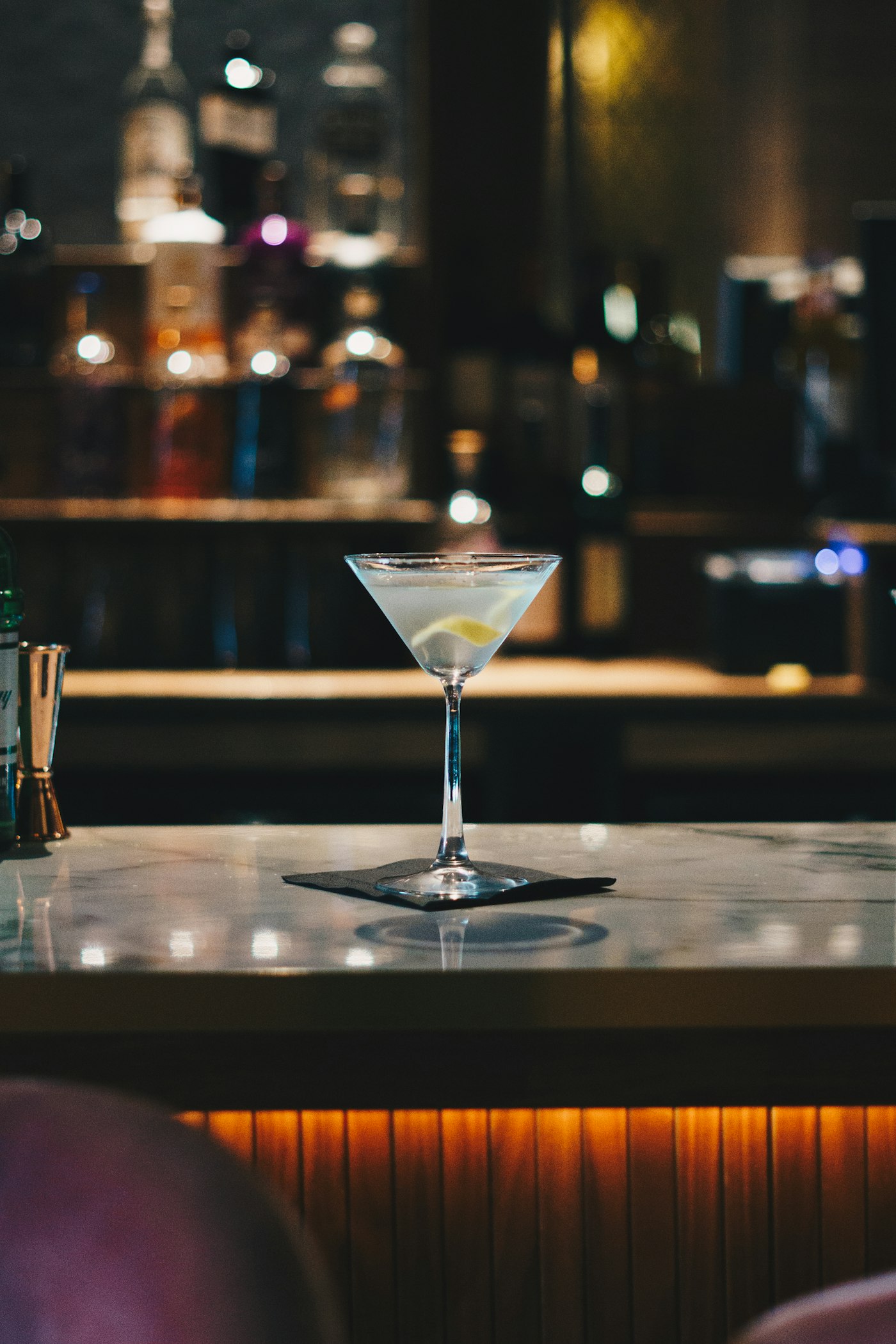 Classic martini on the bar with soft evening bokeh behind