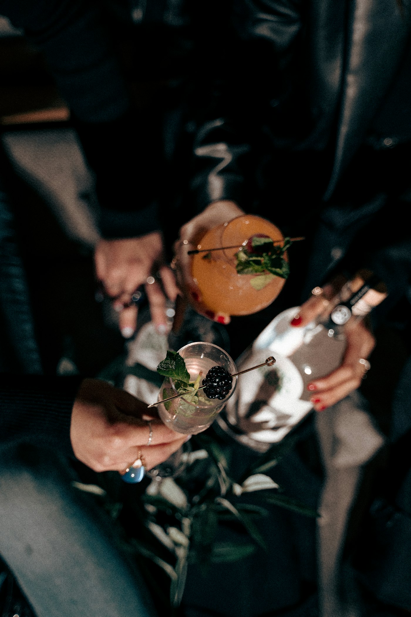 Guests raising garnished craft cocktails at an evening event