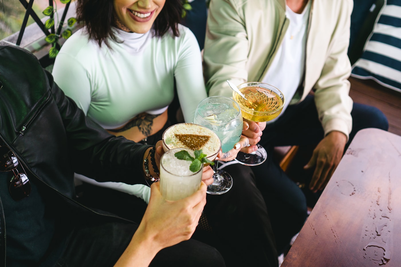 Guests toasting colorful cocktails at a celebration